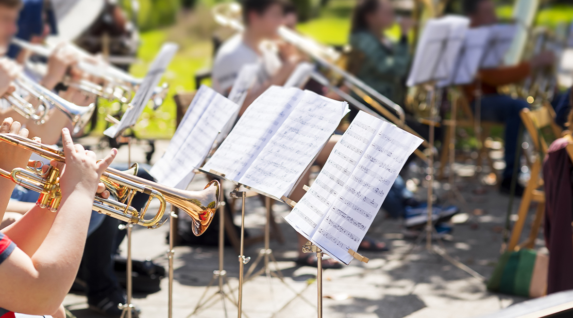 an orchestra playing classical music in a concert outdoors in a park
